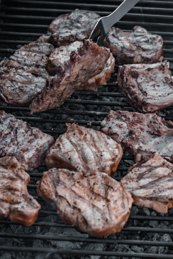 Close-up of succulent steaks sizzling on a hot grill, perfect for a barbecue feast.
